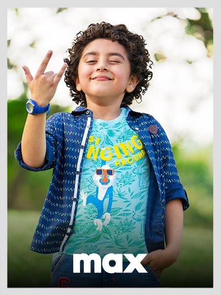 Boy wears a blue graphic tee with a tropical monkey print and an open dark blue patterned shirt. Max kids clothing ad.