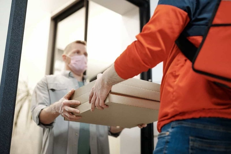 A delivery boy delivering parcel.