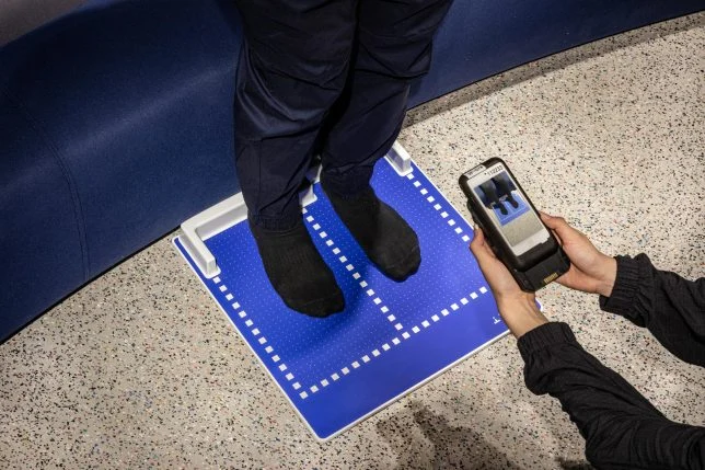 Store Staff assisting customers with shoe size using Nike’s foot-scanning technology