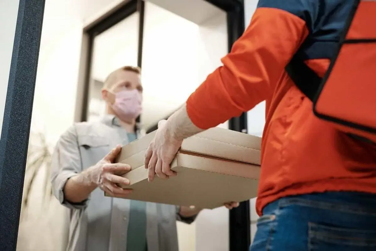 A delivery boy delivering parcel.