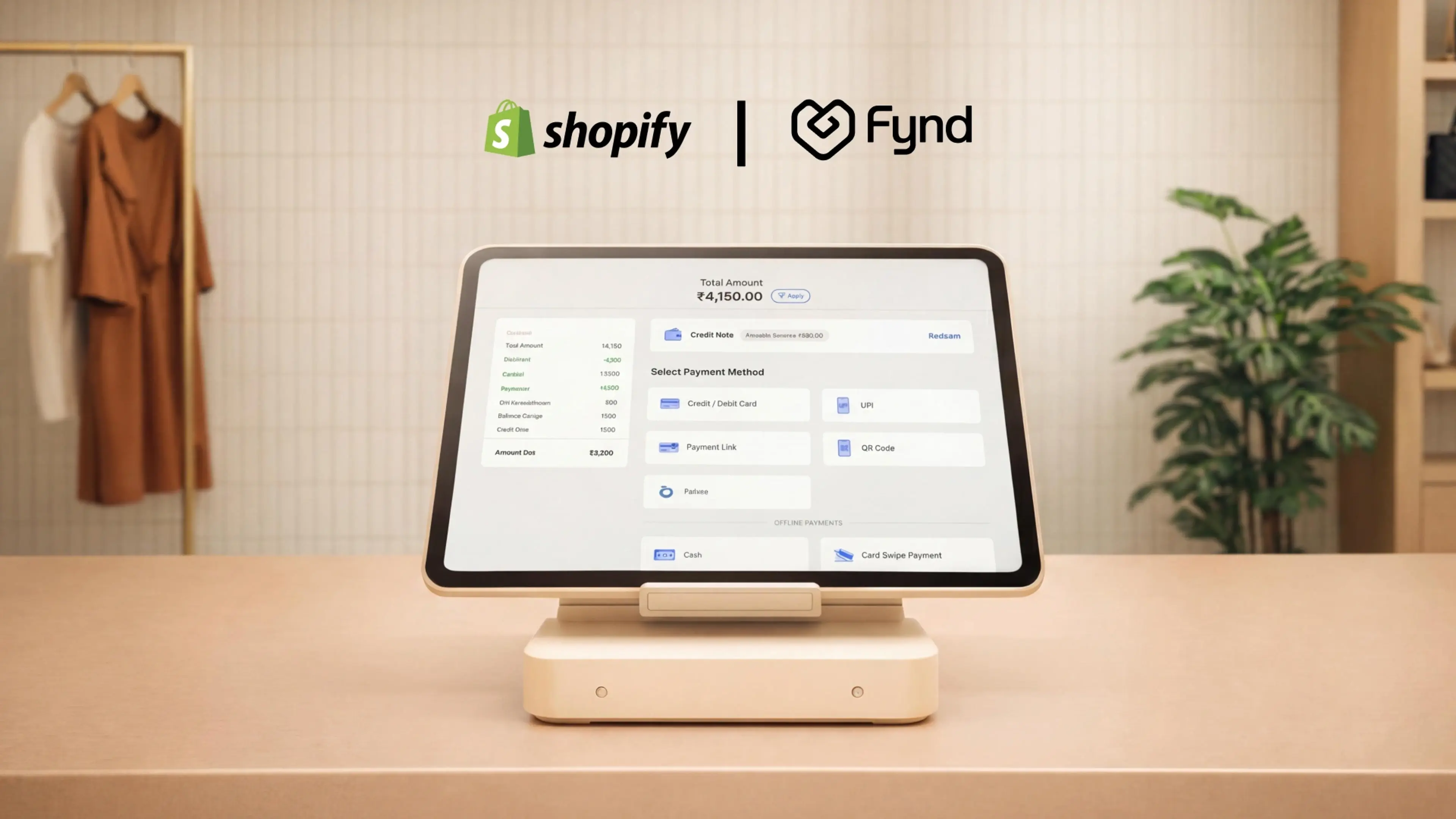 A retail checkout counter with a POS terminal with logo of Shopify and Fynd