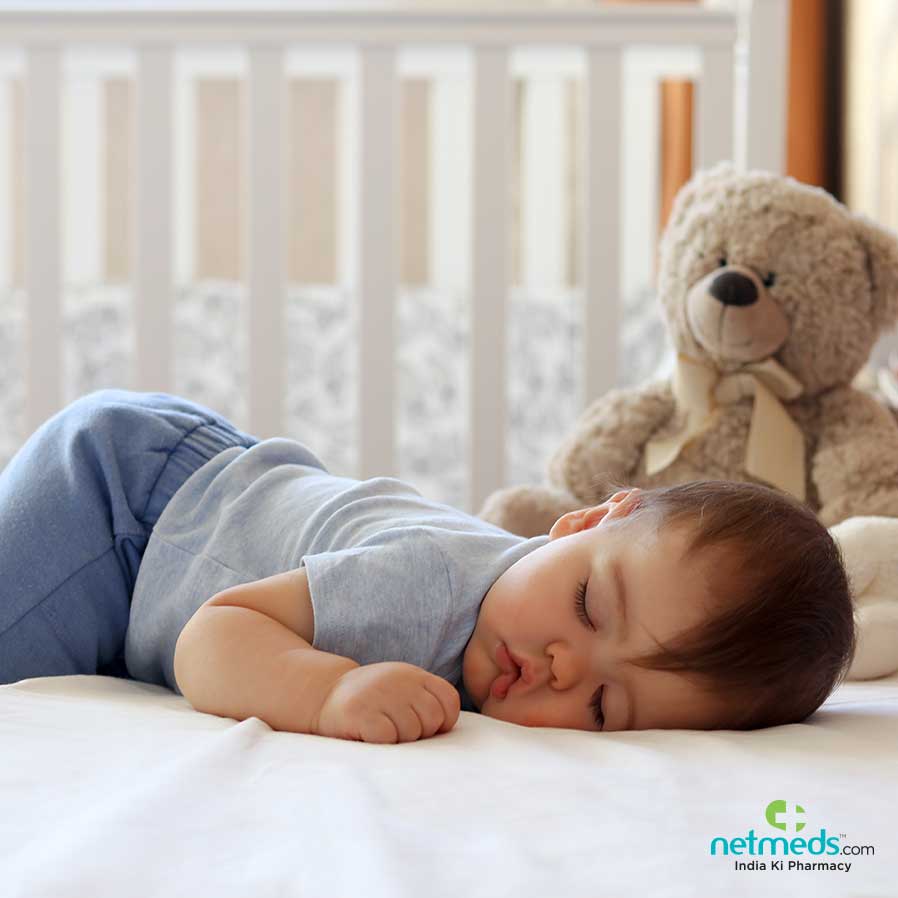 Baby sleeping with a teady bear next to him