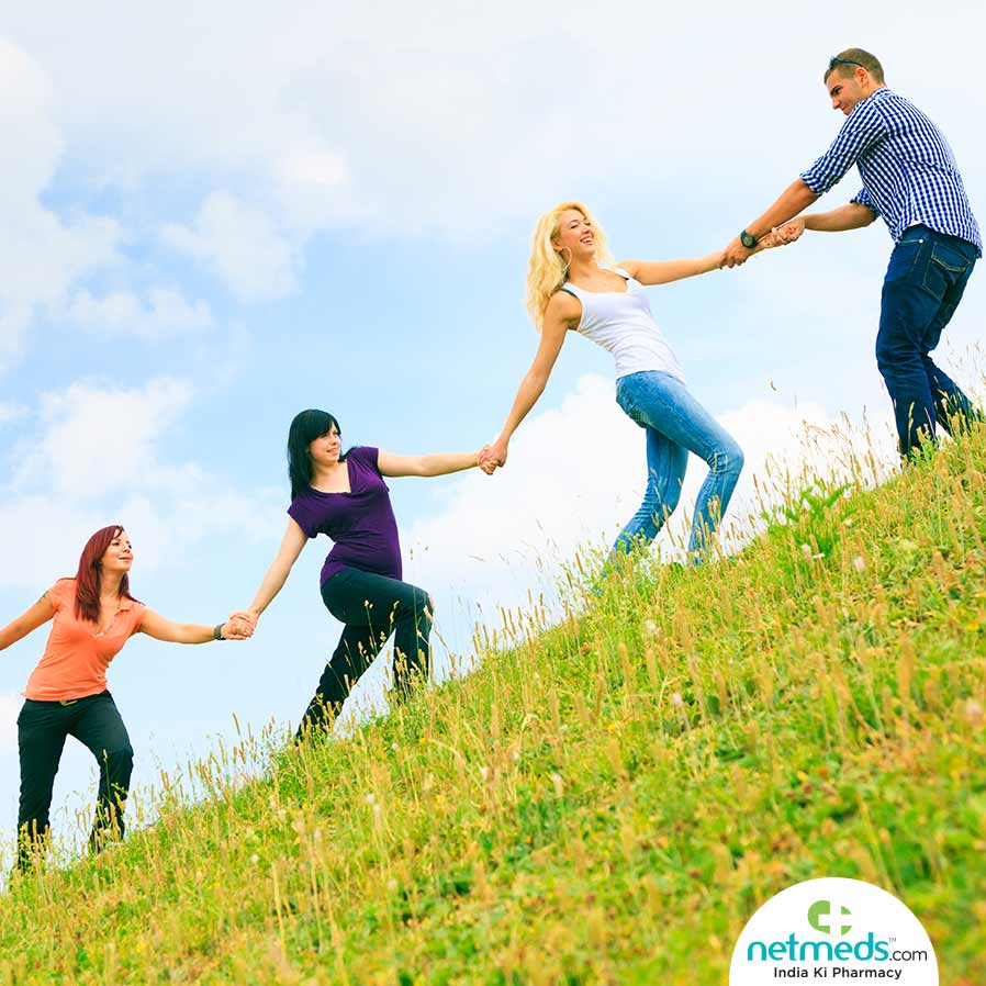 Three women and one man holding hands in a row