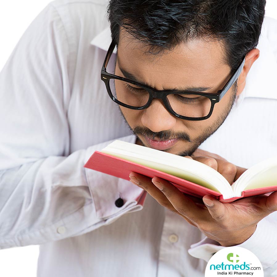 Man with glasses, struggling to read