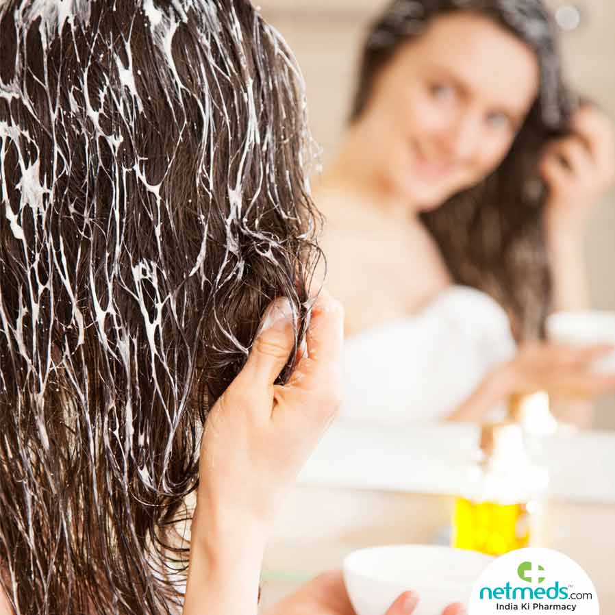 Woman applying Natural Conditioner while looking into the mirror