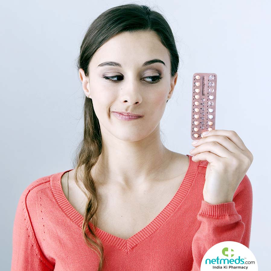 A girl holding birth control pills