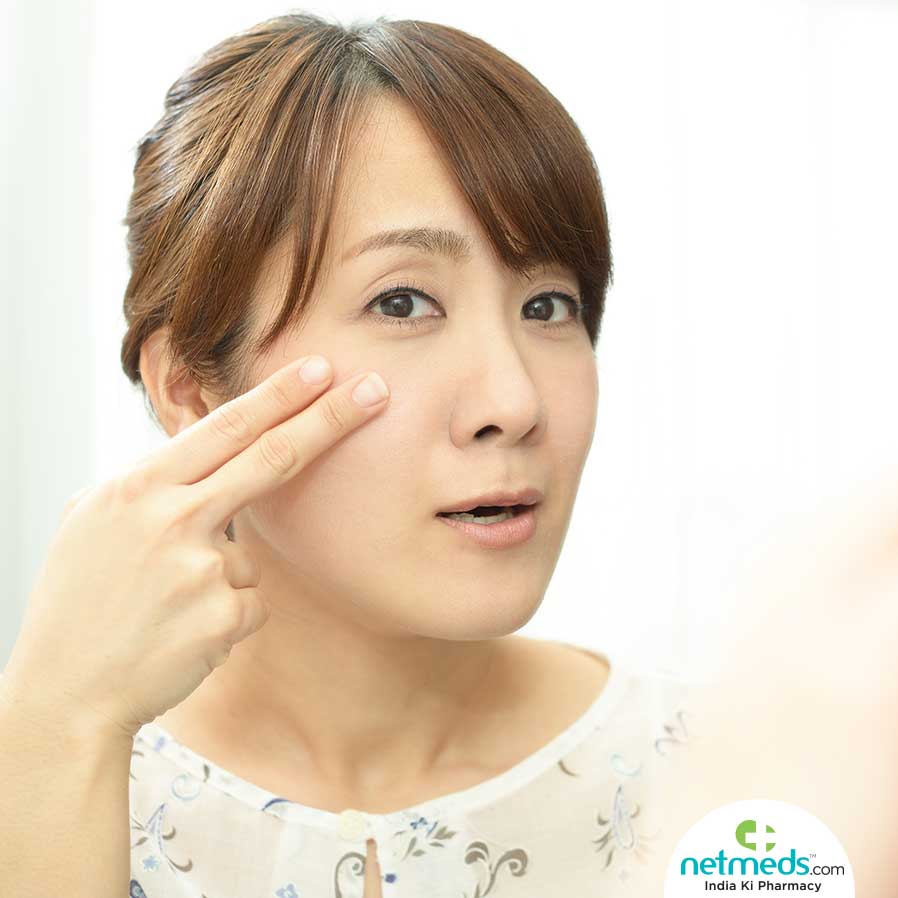 Woman applying cream on her face