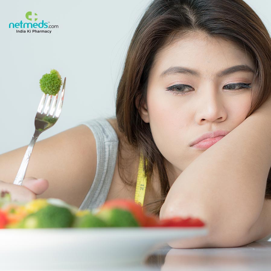 Woman looking at a broccoli sadly