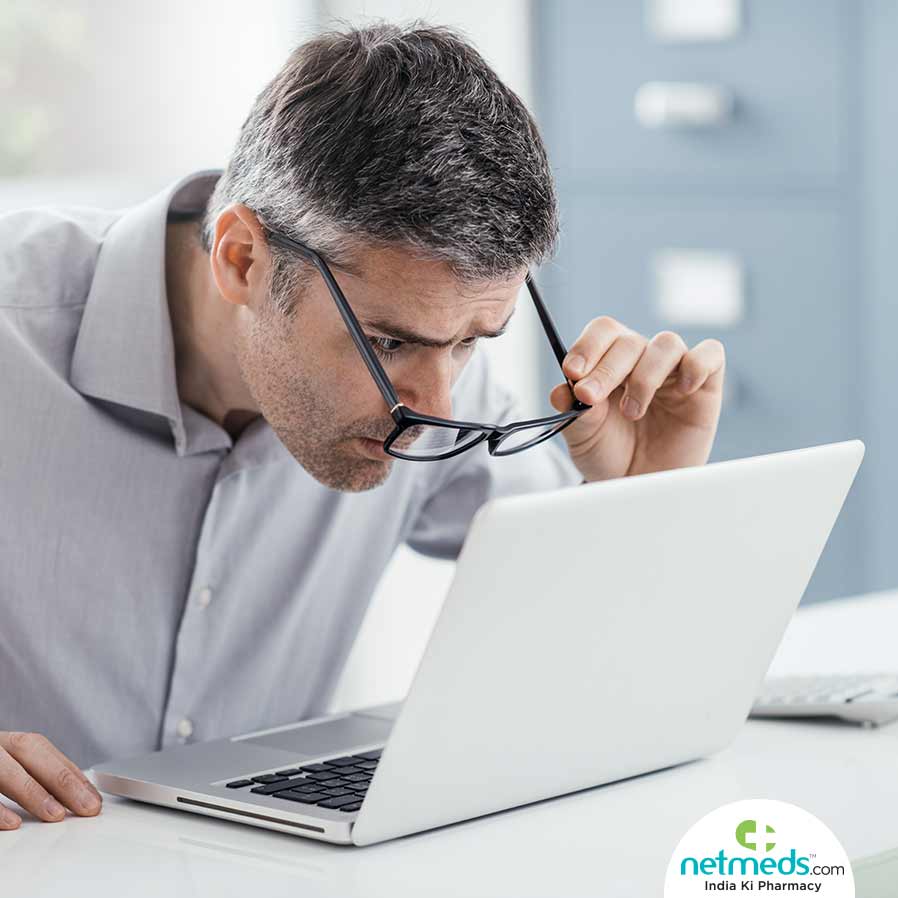 Man with glasses trying hard to read from the laptop