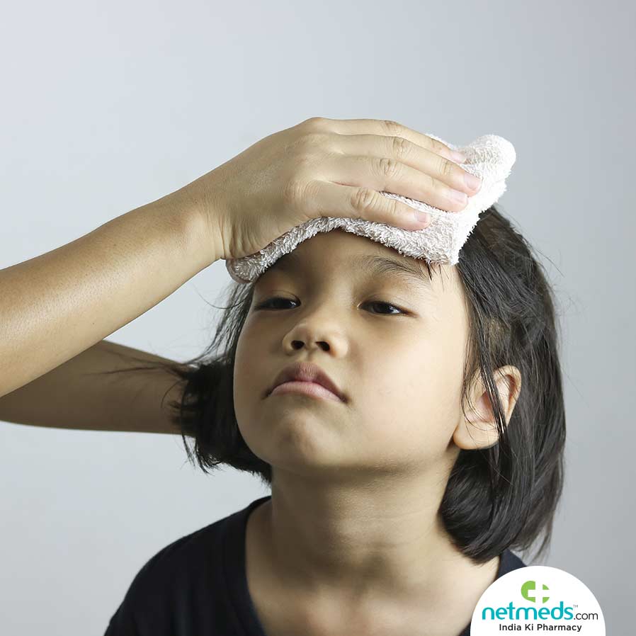 Child with fever has towel on her forehead